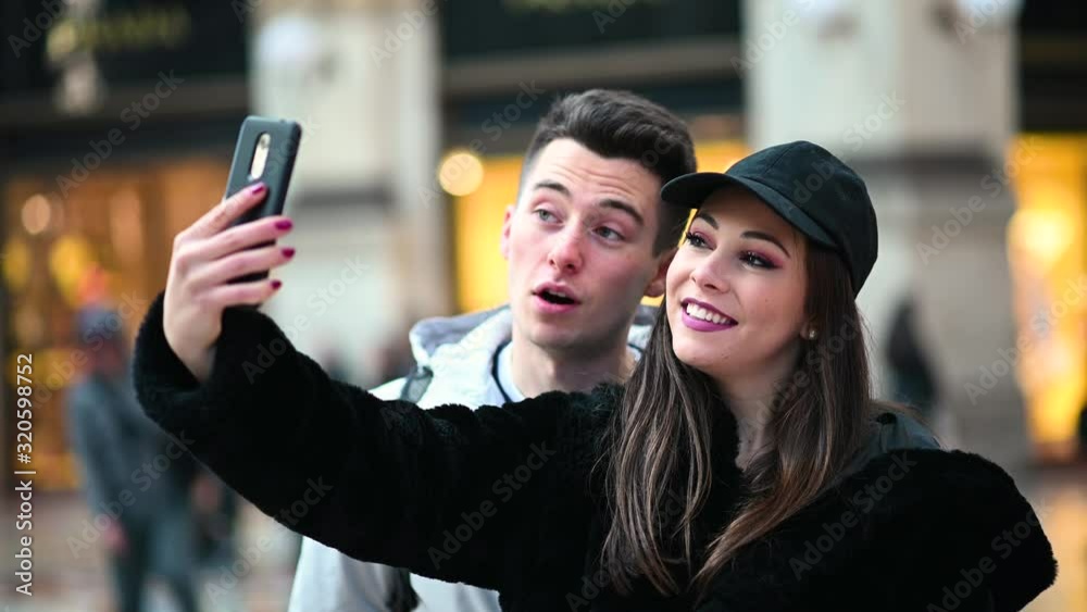 Couple of tourists taking funny selfies in Milan Couple of tourists taking funny selfies in Milan