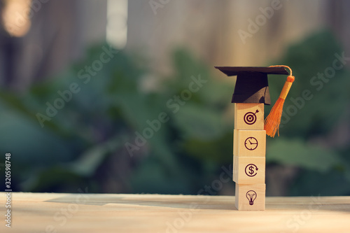 Arranging wood cube block stacking with icon business strategy and graduation cap, diploma in classroom. graduate certificate program, Education insight concept