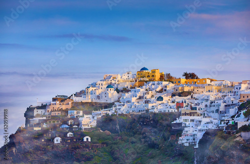 Fira town on Santorini island, Greece. Incredibly romantic misty sunrise on Santorini. Oia village in the morning light. Amazing sunset view with white houses. Island lovers