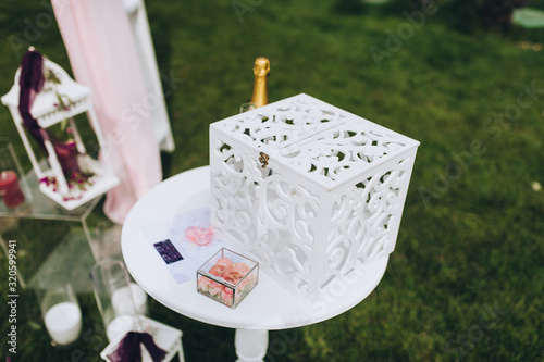 Wedding accessories, jewelry, details at the ceremony and celebration: stand, box, rings, flowers. Photography, concept. photo