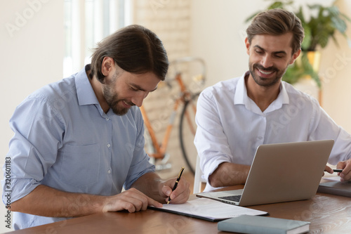 Smiling male employee sign contract close deal at meeting