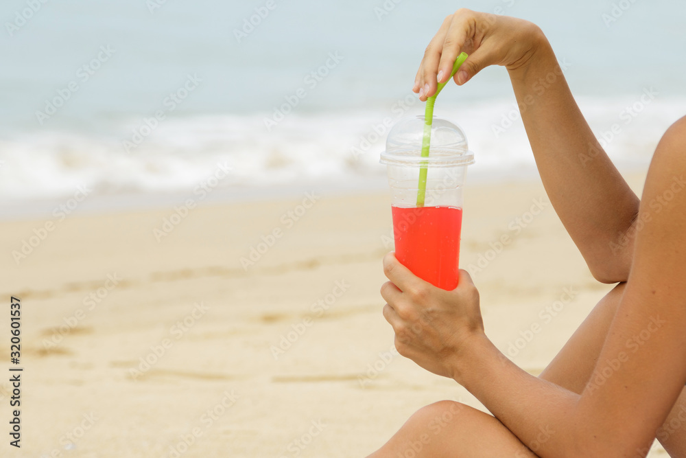 Woman with a red refreshing drink on the beach Woman with a red refreshing drink on the beach