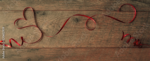 Heart shaped red ribbon on wood background , valentine background in vintage style