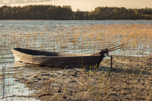Boat moored on the mudy shore lake photo
