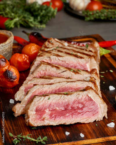 Keto ketogenic diet grilled fried beef steak, striploin on cutting board, side view, vertical