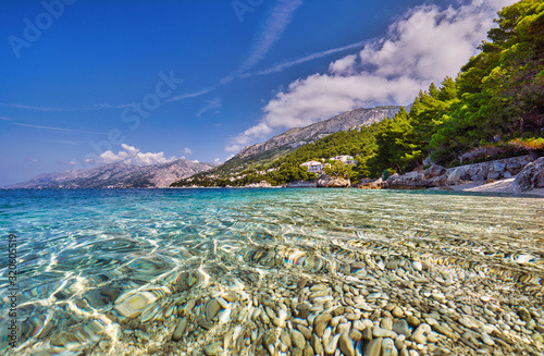 Amazing seascape of Adriatic sea.  Colorful summer view of small Brela beach Croatia, Europe. Croatian coast with clear water and pine trees around. Tropical viewpoint for design postcard.