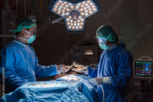 Surgery team operating in a surgical room.Doctors working operation against dark room background.