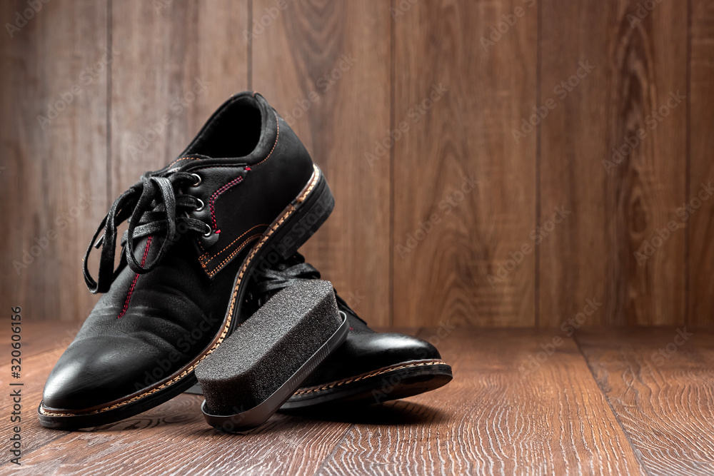 Black shoes one clean second dirty and brush on a wooden background. The concept of shoe shine, clothing care, services. Black shoes one clean second dirty and brush on a wooden background. The concept of shoe shine, clothing care, services.
