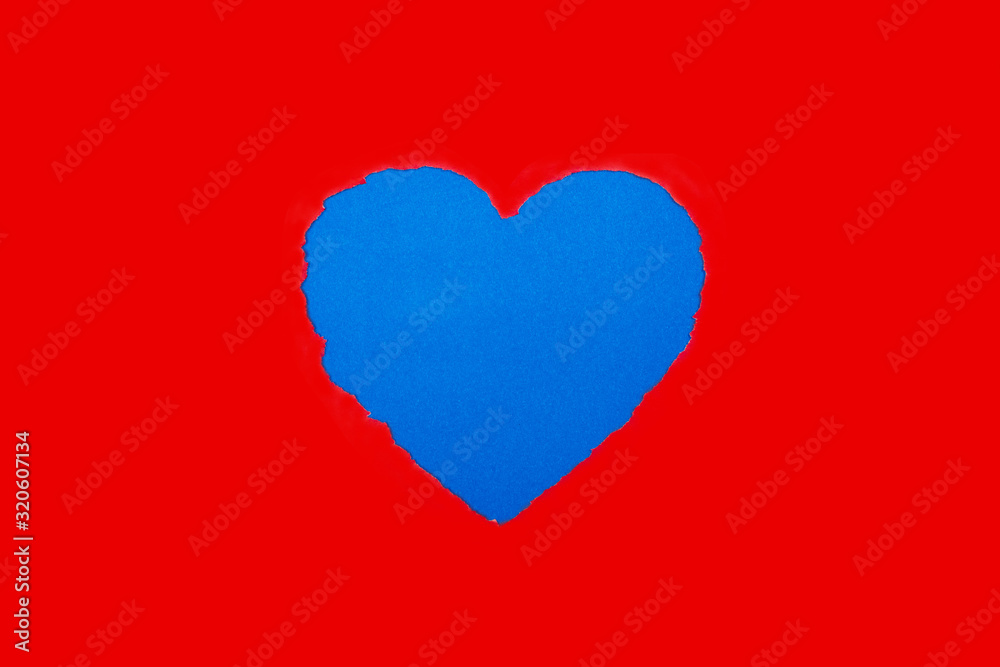 Torn heart shaped in red paper and blue background