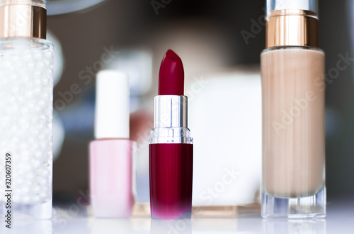 Foto Cosmetics, makeup products on dressing vanity table, lipstick, foundation base,