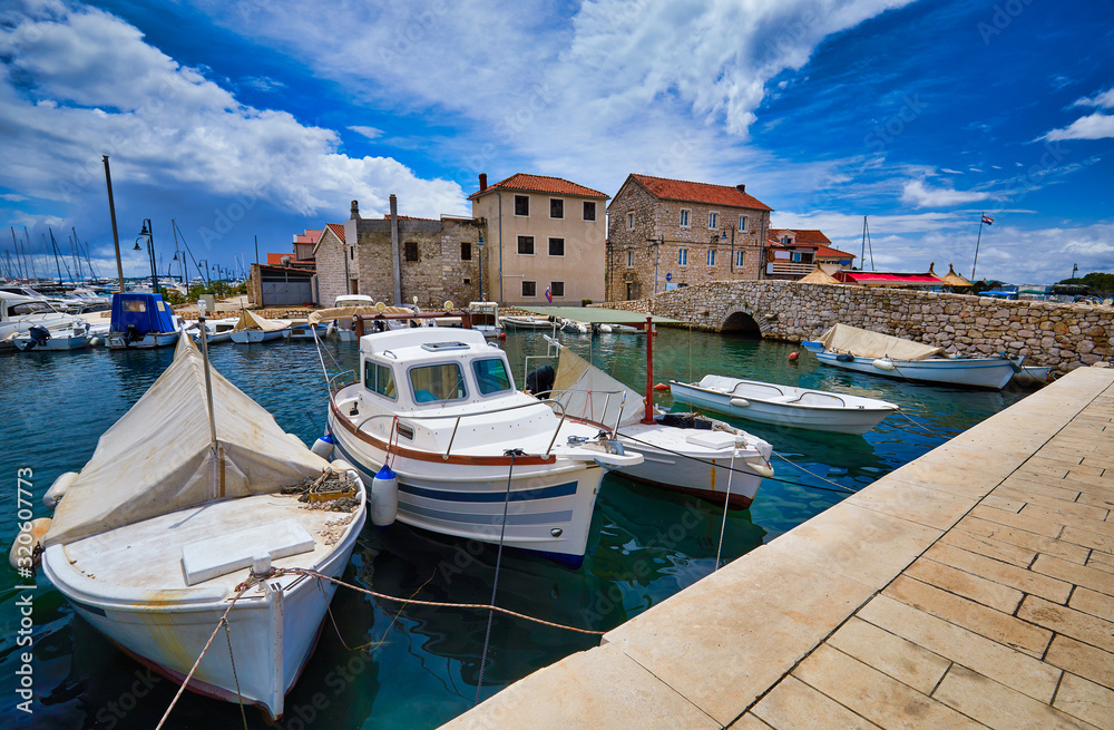 Fishing and sailing boats at the harbor. Sunny summer view of Tribunj port. Morning seascape, Adriatic sea, Croatia, Europe. Beautiful world of Mediterranean countries. Traveling concept background..