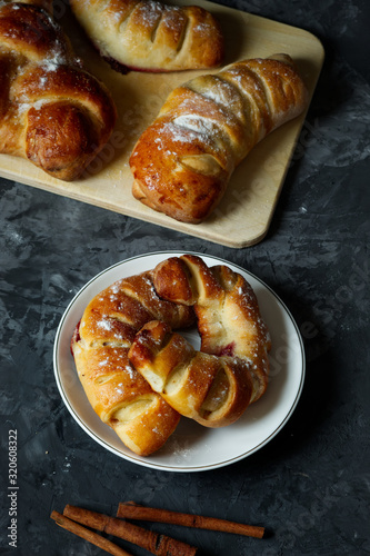 Fresh bakery Variety of homemade puff pastry buns cinnamon rolls and croissant on Dark background. Dark still life. Copy space