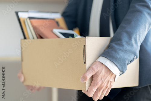 Stressful businessman packing a box for quit a job.