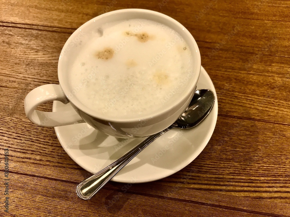 cappuccino Cup on a large wooden table cappuccino Cup on a large wooden table