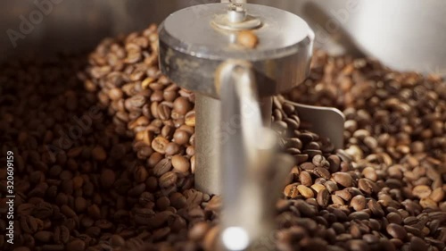 The blades mix the coffee beans in the drum. Cooling coffee beans after roasting in an oven. photo