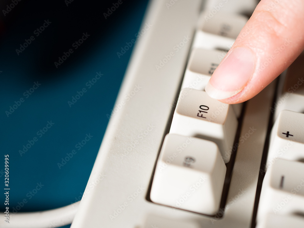 Female forefinger pushes F10 button. Close-up Female forefinger pushes F10 button. Close-up