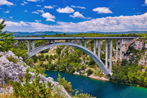 Sunlight view on the Sibenik Bridge a long concrete arch bridge passing through the canyon of the Krka River. Location Skradin town, Croatia, Europe. Travel destination. Discover the beauty of earth