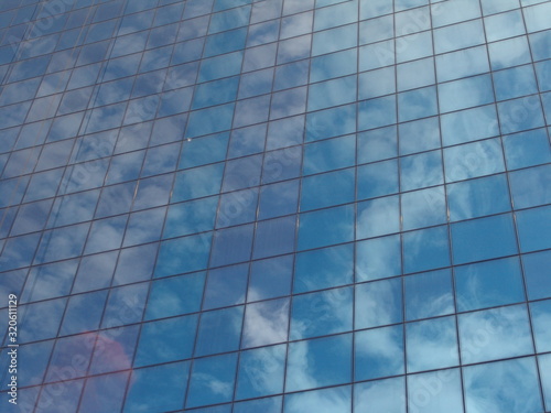 reflection in the mirrored blue windows of a skyscraper