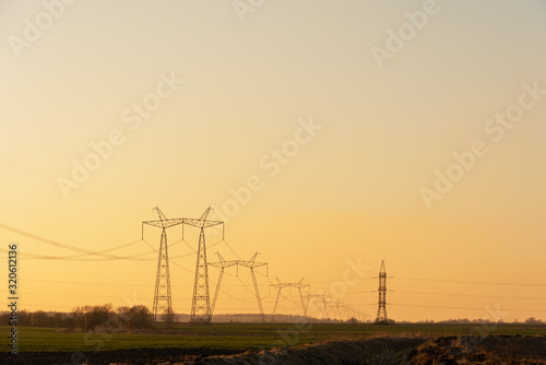 Electric poles with high voltage lines on the background of beautiful fields © reme80