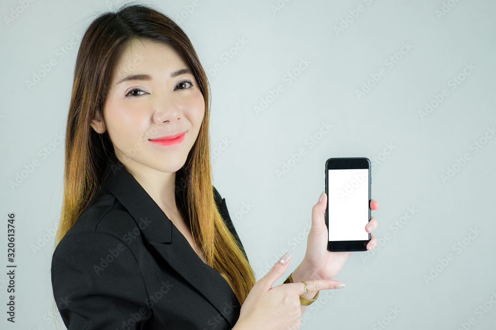 Portrait of stressed asian business woman showing and pointing to empty white mobile screen. Caucasian female model isolated on white background. selective focus Portrait of stressed asian business woman showing and pointing to empty white mobile screen. Caucasian female model isolated on white background. selective focus