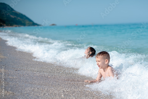 Two kids are playing and on the beautiful, pebbly beach © Jovan