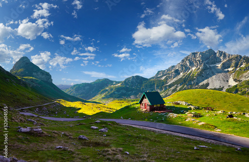 Amaizing sunset view on Durmitor mountains, National Park, Mediterranean, Montenegro, Balkans, Europe.  Bright summer view from Sedlo pass. Instagram picture. The road near the house in the mountains photo