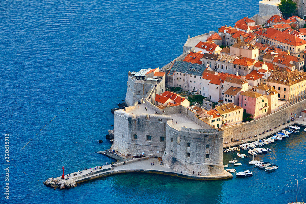 Aerial view at famous european travel destination in Croatia, Dubrovnik old town, Dalmatia, Europe. UNESCO list. Beautiful sunset view over the historic old Fort Bokar seen in dramatic light. Roofs