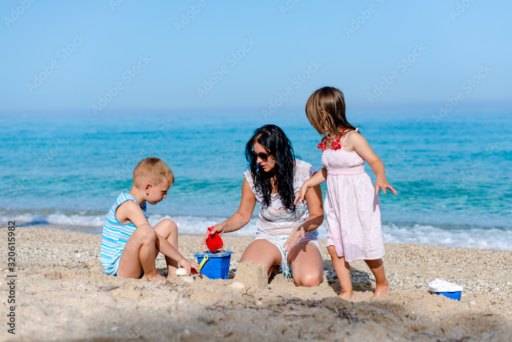 Mother is playing with kids by the water Mother is playing with kids by the water