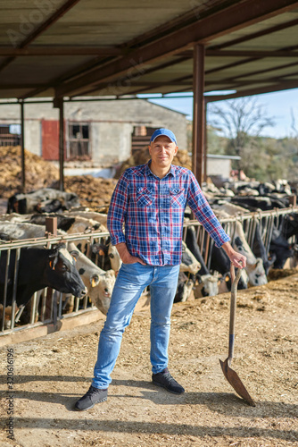 Portrait of a man on livestock ranches with a shovel.