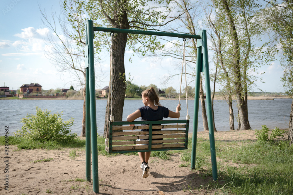 Young woman swinging on a swing. Girl sitting on a swing Young woman swinging on a swing. Girl sitting on a swing