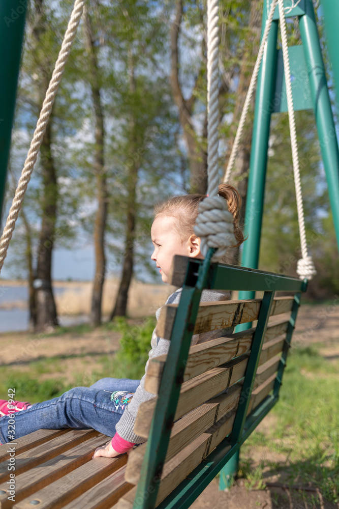 Fototapeta premium Child swinging a swing. child sitting on a swing