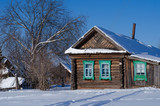 Winter landscape on a Sunny day. View of the Russian village in the snow. Authentic Wooden houses with carved frames.