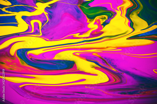 Multicolored acrylic paint flowing fluid trend bright colorful background.