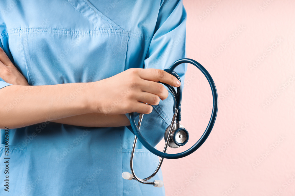 Doctor with stethoscope on pink background, closeup. Medical service Doctor with stethoscope on pink background, closeup. Medical service