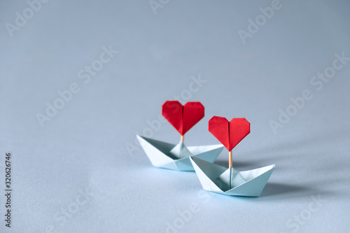 Valentine's day greeting card. Origami boat with heart flag on glitter blue background Romantic, Valentines day concept with space for text.