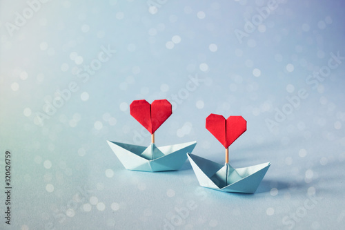 Valentine's day greeting card. Origami boat with heart flag on glitter blue background Romantic, Valentines day concept with space for text.