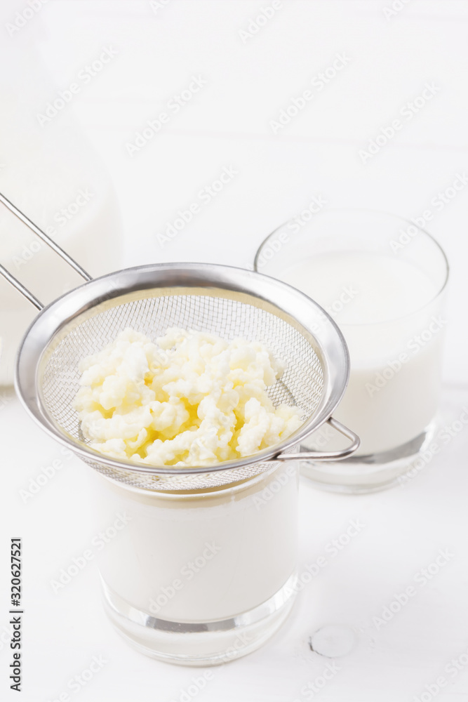 Homemade fermented beverage kefir with kefir grains in bowl on a white background, concept of natural fermented food and gut health Homemade fermented beverage kefir with kefir grains in bowl on a white background, concept of natural fermented food and gut health