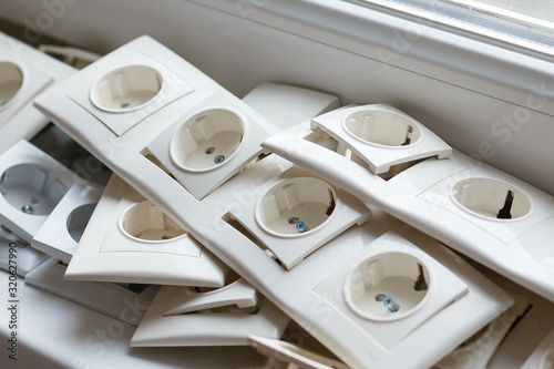 Tv coaxial sockets and the stack of socket frames on the light windowsill photo