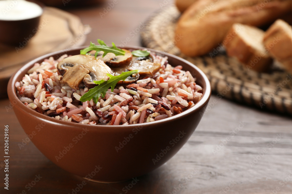 Delicious brown rice in bowl on wooden table Delicious brown rice in bowl on wooden table