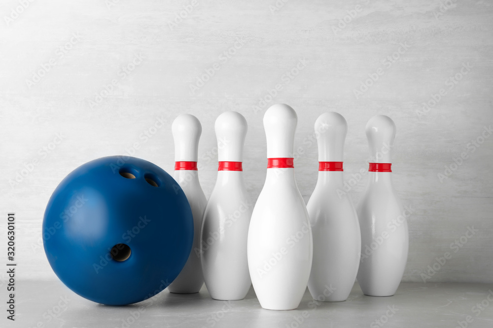 Blue bowling ball and pins on light grey marble table Stock Photo