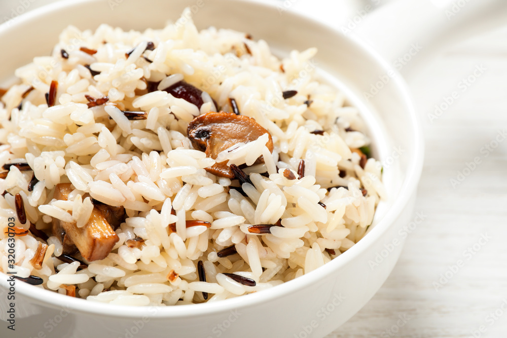 Delicious rice pilaf with mushrooms on white table, closeup Delicious rice pilaf with mushrooms on white table, closeup
