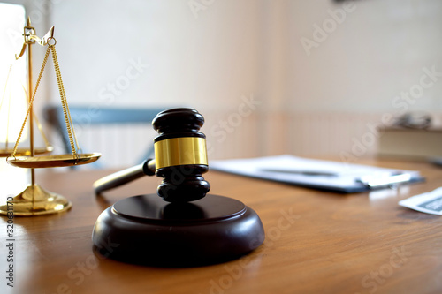 Justice law Scales and books and wooden gavel tool on desk in Lawyer office.concept