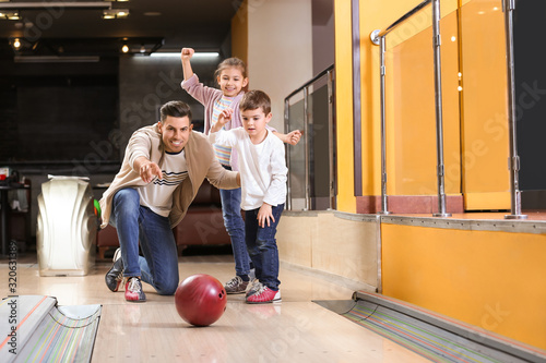 Canvas Print Happy family spending time together in bowling club