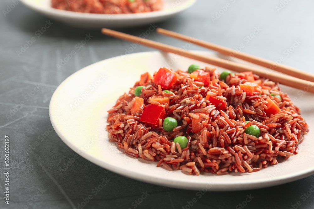 Tasty brown rice with vegetables on table, closeup Tasty brown rice with vegetables on table, closeup