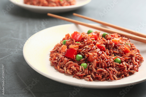 Tasty brown rice with vegetables on table, closeup