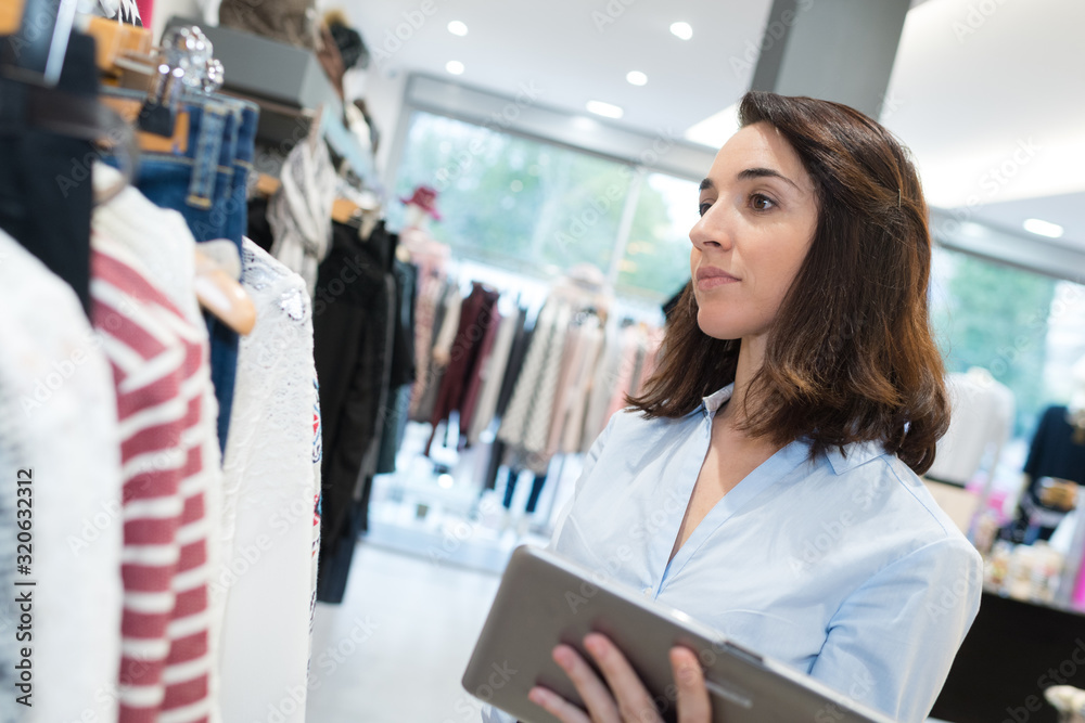 woman in clothes store with digital tablet woman in clothes store with digital tablet