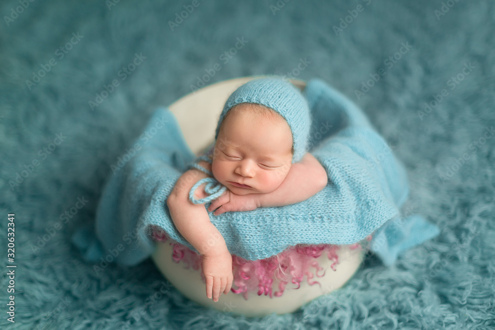 first photo session. a newborn baby in a barrel. little girl in a blue hat first photo session. a newborn baby in a barrel. little girl in a blue hat