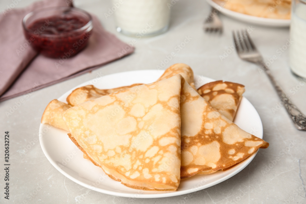 Folded fresh thin pancakes on light grey table Folded fresh thin pancakes on light grey table