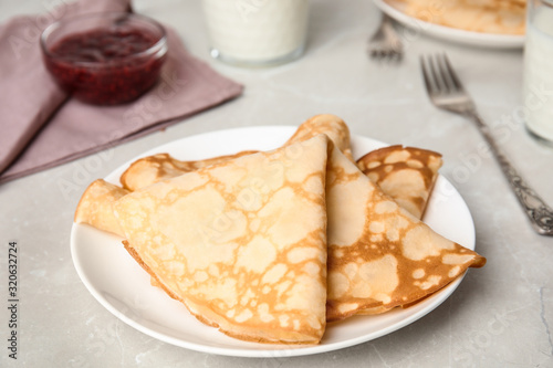 Folded fresh thin pancakes on light grey table