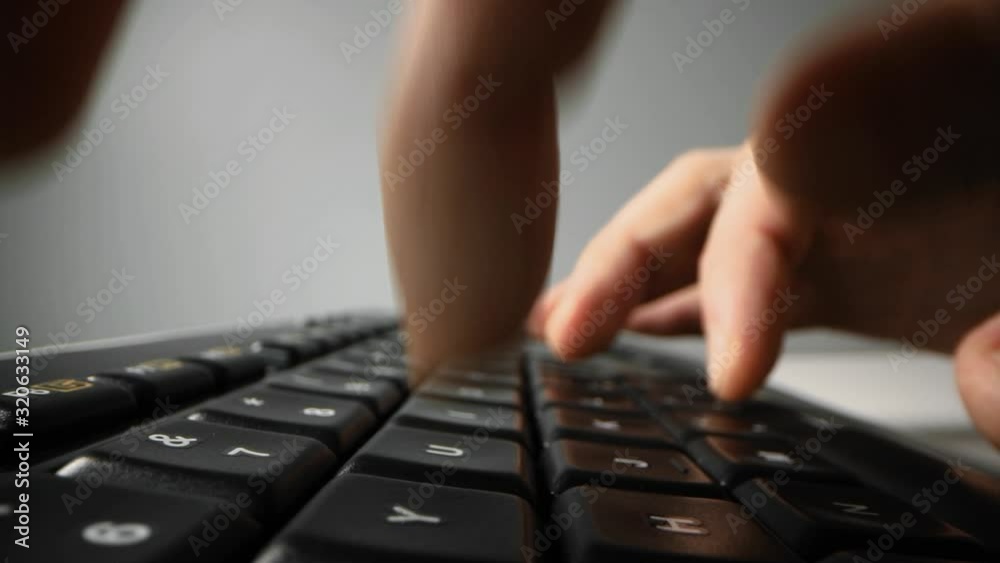 fingers typing on black computer keyboard. closeup dolly shot